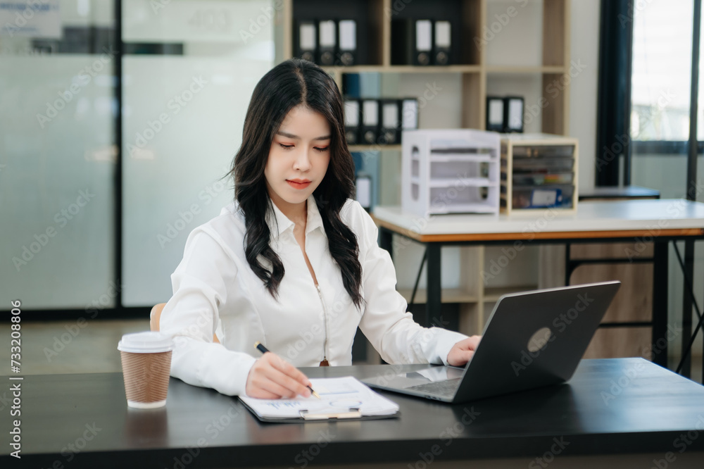 Asian businesswoman working in the office with working notepad, tablet and laptop documents . Asian businesswoman working in the office with working notepad, tablet and laptop documents .
