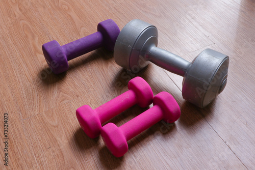 dumbbells with plastic coating on a wooden background