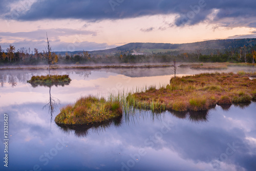 Beautiful lake with reflecions during foggy autumn morning