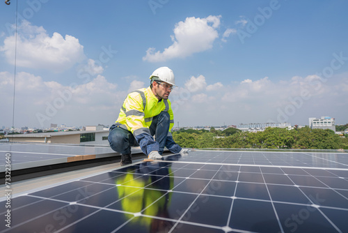 Service Engineer use tablet working inspection installation solar cell on the roof. Technician maintenance solar cells on roof factory. Technology solar energy renewable.