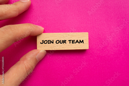 Join our team lettering on wooden block with pink background. Business recruitment symbol. Copy space. Top view.