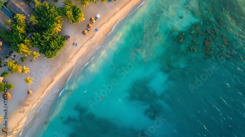 Aerial view of a beach, crystal clear turquoise water, palm trees, and a bustling promenade, captured on a high-end drone