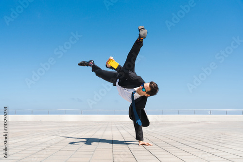 Flexible and cool businessman doing acrobatic trick photo