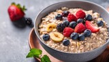 A bowl of oatmeal with berries and bananas