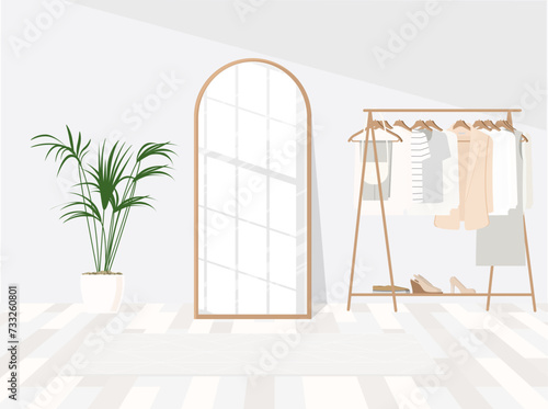 Stylish dressing room interior with mirror, ottoman and clothing rack