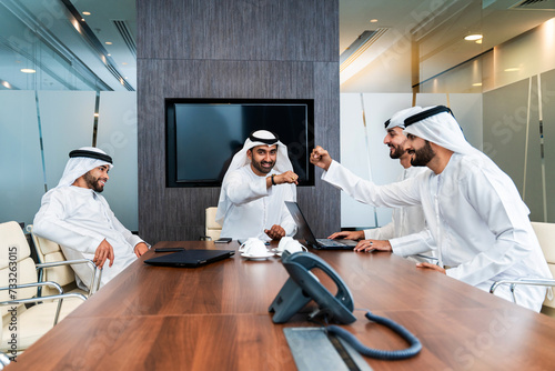 Group of corporate arab businessmen meeting in the office - Business people wearing emirati clothing  working in the office photo