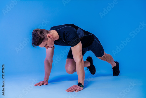 Athletic man with fit muscular body training in studio