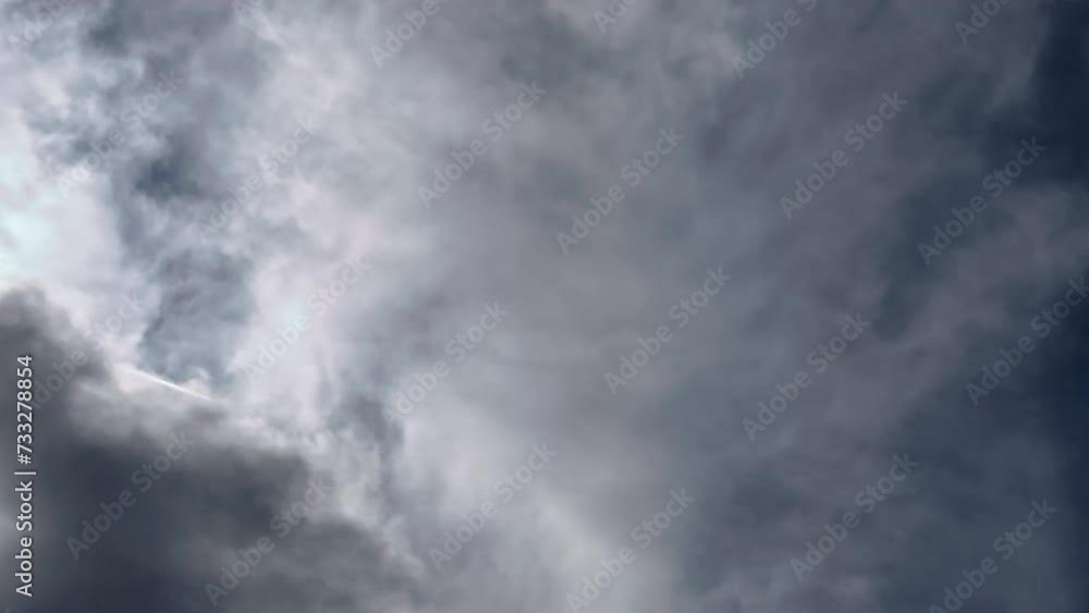 Jet contrail stretching and crossing the sky in the middle of the thick clouds. Cloudscape. Jet contrail stretching and crossing the sky in the middle of the thick clouds. Cloudscape.