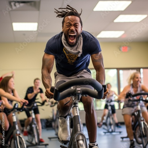 a Spinning Class Participant Radiating Energy and Enthusiasm While Riding Hard on a Stationary Bike © cristian