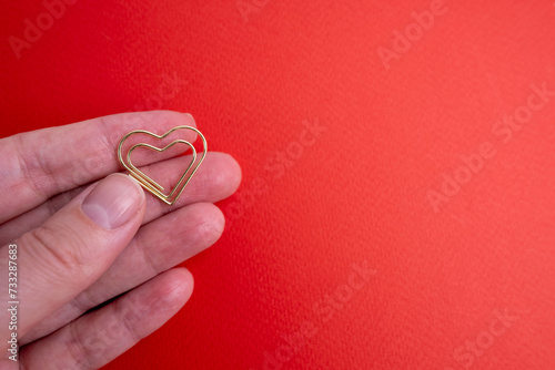 Background for design for Valentine s Day. Decorative heart made of gold on a red background. View from above. Valentine s Day concept