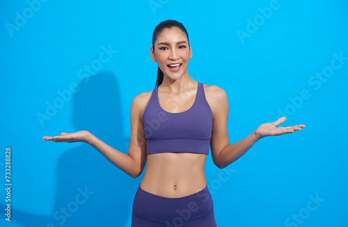 Happy Asian Sporty girl wearing sportswear open hands isolated on blue background. fitness workout concept.