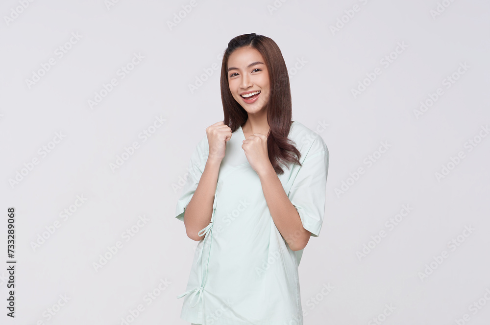 Happy asian woman patient raise fist gesture fight disease isolated on white studio background. life insurance and coverage concept. Happy asian woman patient raise fist gesture fight disease isolated on white studio background. life insurance and coverage concept.