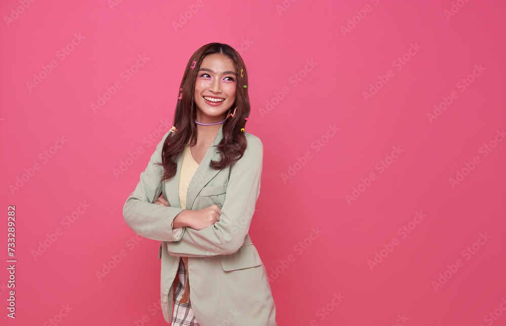 Young happy asian teen woman arms crossed and looking something away to side with smile on face isolated on pink copy space background. Young happy asian teen woman arms crossed and looking something away to side with smile on face isolated on pink copy space background.