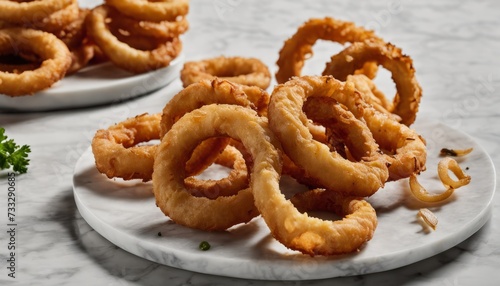 A plate of onion rings with a side of french fries