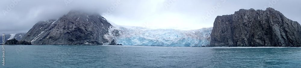 Panorama of a glacier meeting the sea along a rugged cloastline on Elephant Island, Antarctica