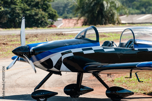 Single-engine aerobatic display plane being parked at a flying club