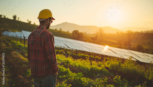 Worker on a solar farm. Photovoltaic system. Solar power generation. Solar plant. Sustainable electricity from solar energy. Energy transition. Sustainable energy generation. Clean energy. At Sunset.