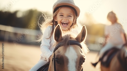 Smiling girl riding horse at equitation lesson, wearing helmet, looking at camera photo