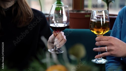 Two women clink wine glasses in a restaurant