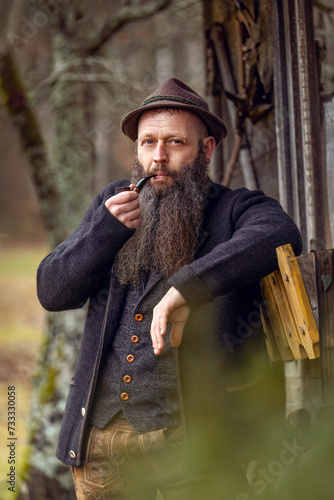 Portrait of a typical bavarian man smoking a pipe and wearing a traditional folk costume photo