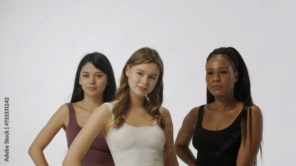 Portrait of young multiethnic models on white studio background close up. Group of three appealing multiracial girls standing posing at the camera Multiethnic beauty concept. Portrait of young multiethnic models on white studio background close up. Group of three appealing multiracial girls standing posing at the camera Multiethnic beauty concept.