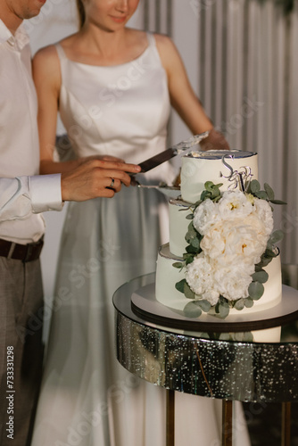 newlyweds happily cut and taste the wedding cake