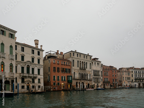 Facades of weathered buildings with windows on street of Venice city near canal water in daylight