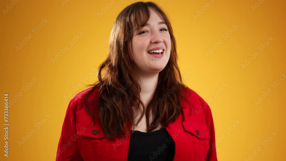 Portrait of young woman 20s looks at camera accepts applause of audience from great performance, thank you to people for support for a good performance. Isolated on yellow background Portrait of young woman 20s looks at camera accepts applause of audience from great performance, thank you to people for support for a good performance. Isolated on yellow background