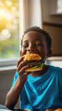 cheerful smiling black african american boy with big hearty burger, child eating enjoying homemade hamburger in sunny kitchen at home .