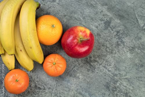 Fruits. Bananas, apples, oranges, tangerines on a biton background. photo