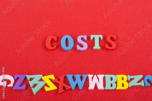 costs word on red background composed from colorful abc alphabet block wooden letters, copy space for ad text. Learning english concept.