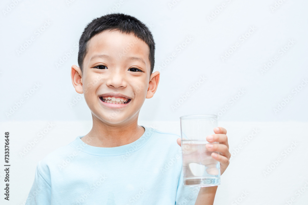 little Asian boy with a glass in his hand of water. shot of a child holding a glass of cold water. little Asian boy with a glass in his hand of water. shot of a child holding a glass of cold water.
