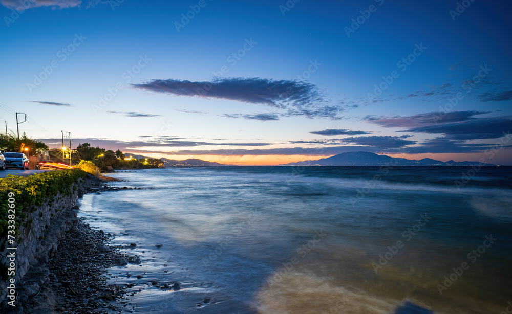 Long exposure shot of a coastal view of Mediterranean Sea during sunset next to car parks near drosia located in Zakynthos, Greece