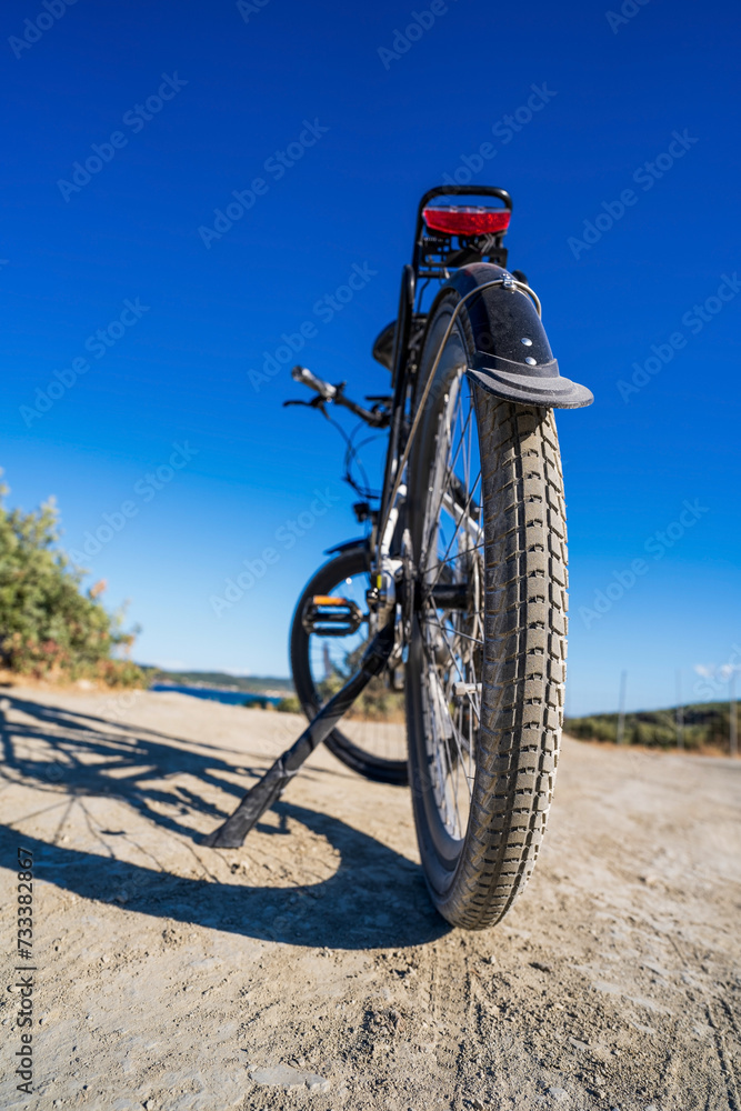 Close up of an electric dirt bike tire against clear blue sky in summer