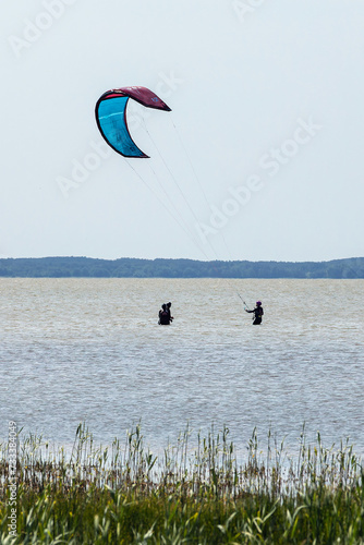 A group of people practicing kite surfing. photo