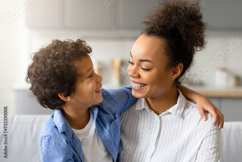 Fotografija Joyful black mother and son share tender moment and embracing at home
