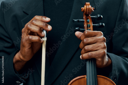 Close up of hands holding the bow of a violin, capturing the delicate touch and artistry of playing music