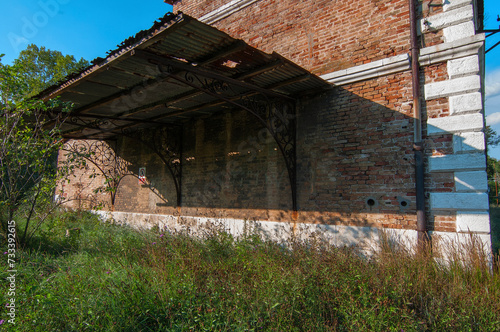 Lato di facciata in mattoni di un antico edificio in stato di abbandono photo