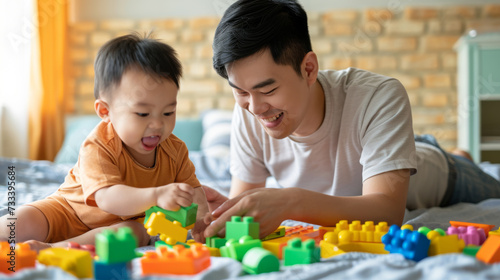 young child and a man, presumably his father, are engaged in play, surrounded by colorful building blocks