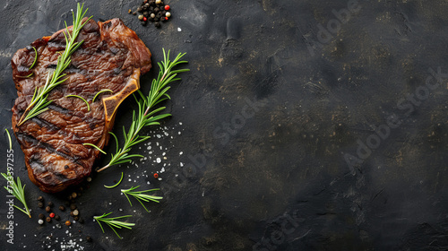 Grilled steak with herbs and spices on a dark textured surface. Place for an inscription.