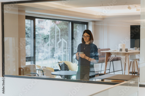 Business woman taking coffee break in modern office space.