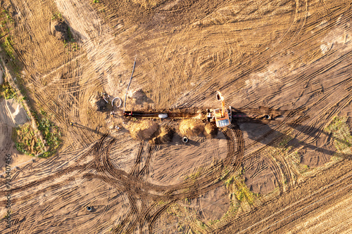 Drone photography of laying underground power line in the middle of the field during autumn morning