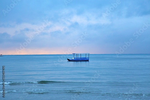 fishing boat parked on coastine, blue sunrise with first sun light of day. Japaratinga, Alagoas, Brazil. 