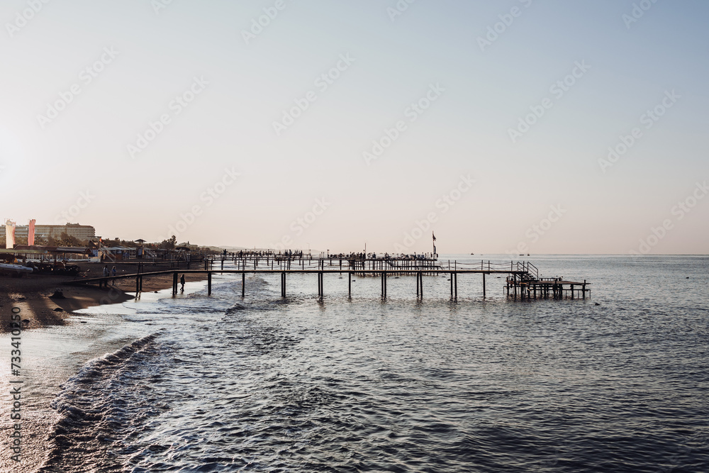 Mediterranean Sea, sandy beach with pebbles and palm trees. relaxation area with sun loungers by the sea.Turkey