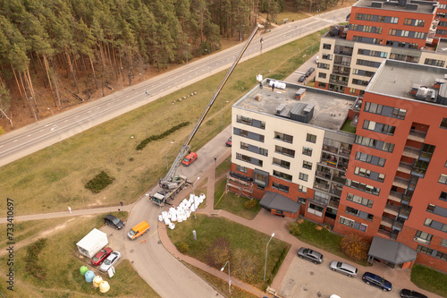 Drone photography of crane removing construction material from the roof during autumn day © M