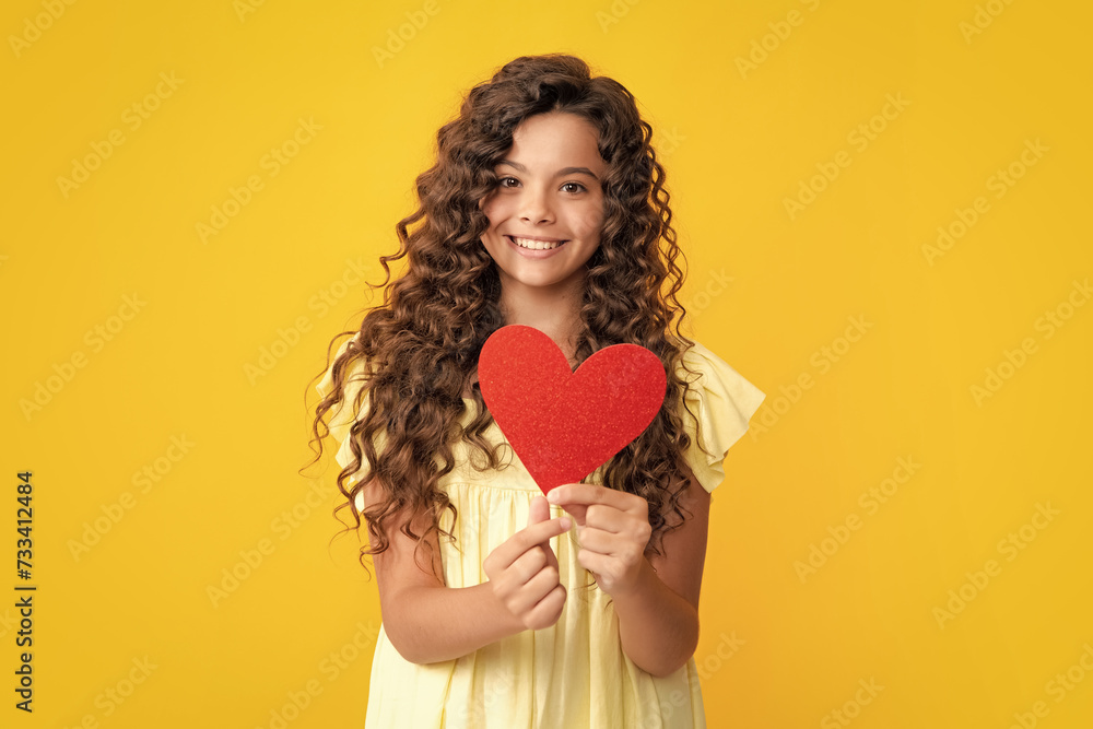 Happy teenager portrait. Lovely child teen girl with shape heart love holiday and valentine symbol. Valentine or birthday day. Gift heart present. Smiling girl.