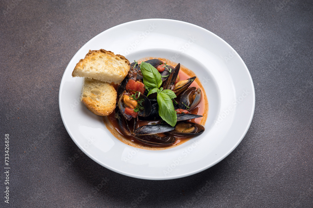 a dish of mussels and basil on a plate. Close up 