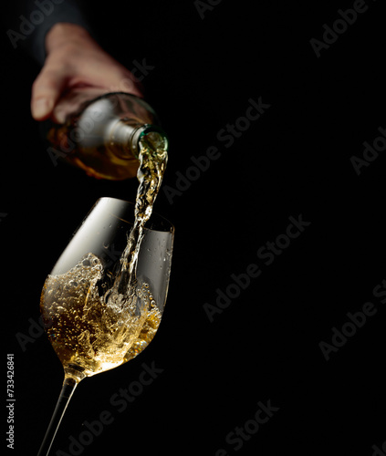 Pouring white wine into a glass.