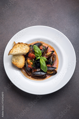 a dish of mussels and basil on a plate. Close up 