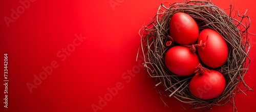 Vibrant Red Easter Eggs in Nest on Red Background photo